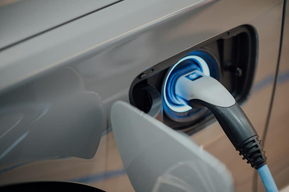 Electric vehicle charger plugged into car