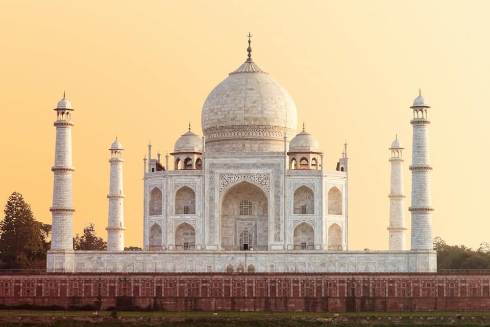 The Taj Mahal in Agra under a warm golden hour sky