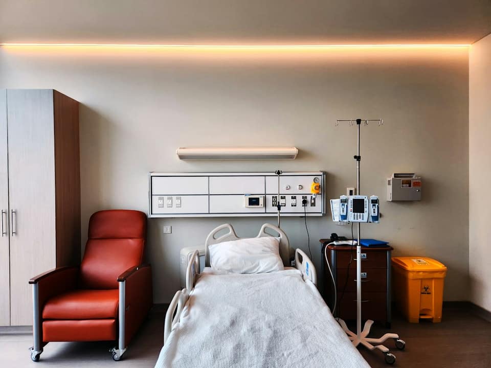 A hospital room with a bed and a chair