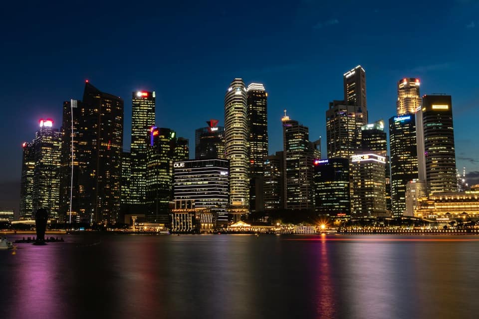 Cityscape near the body of water with lights turned-on during nighttime