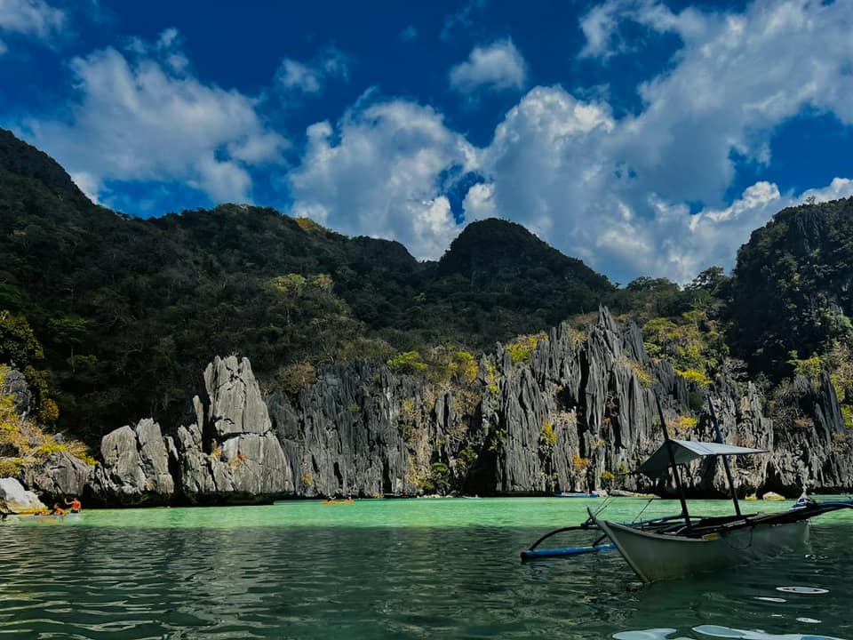 A boat floating on top of a lake surrounded by mountains