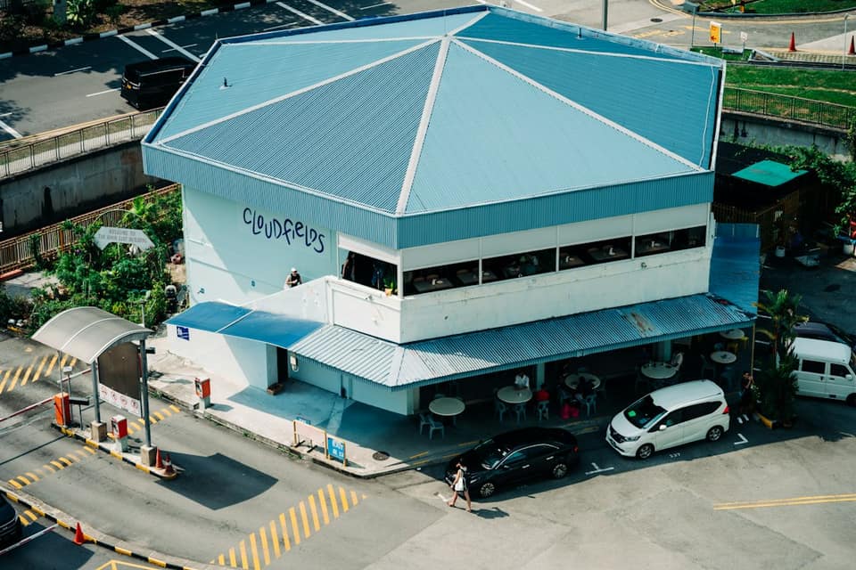 An aerial view of a building with a blue roof and outdoor seating