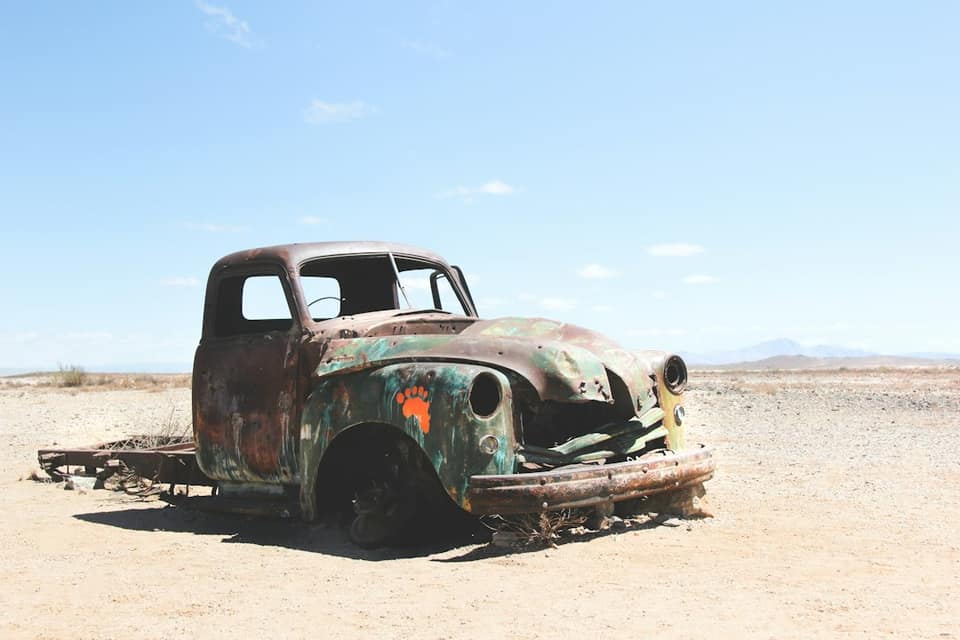 Wrecked single cab pickup truck on field