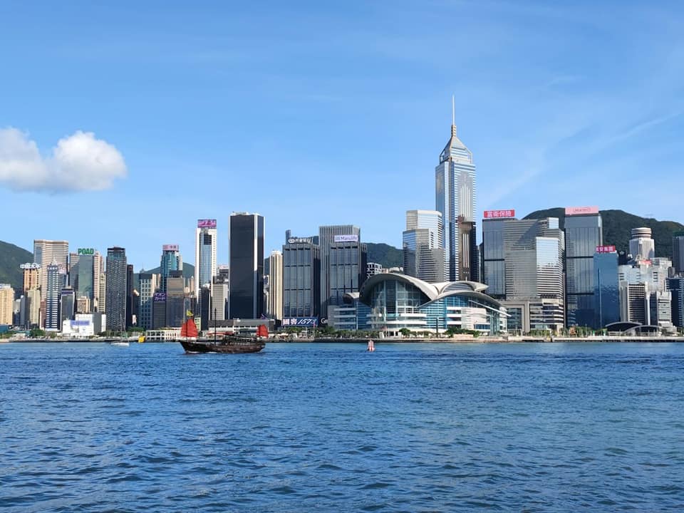 A boat in a body of water with a city in the background
