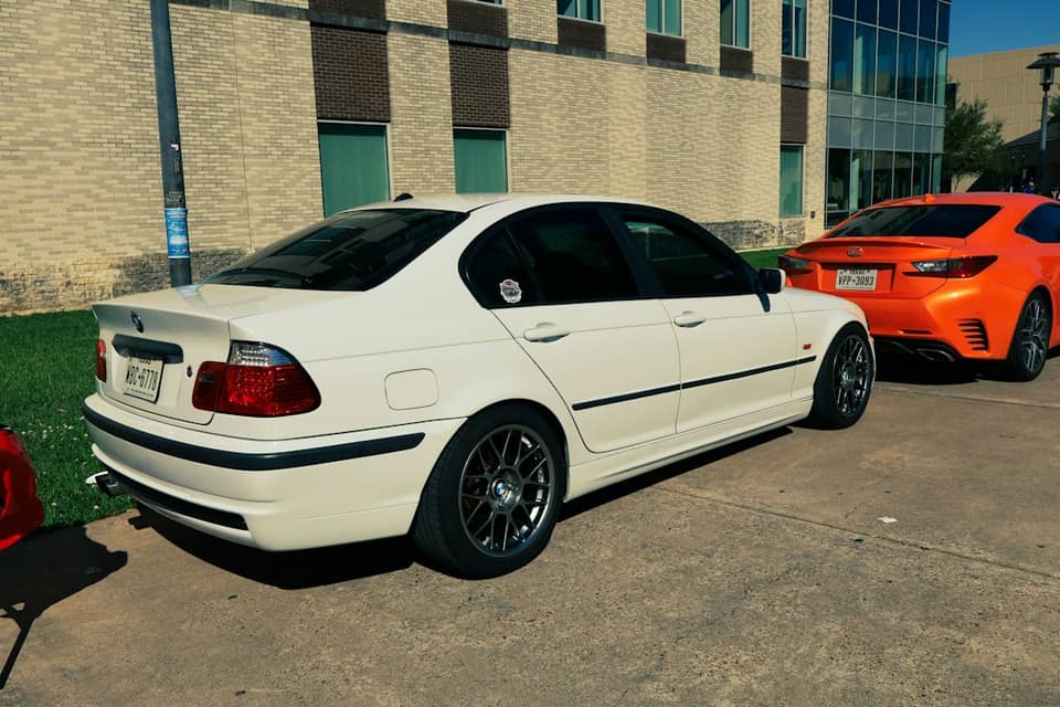 White sedan parked next to an orange car