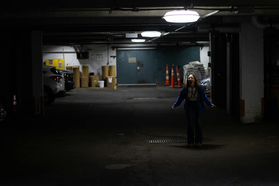 A woman standing in a parking garage at night