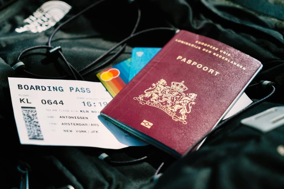 A passport and a boarding pass are on a bag