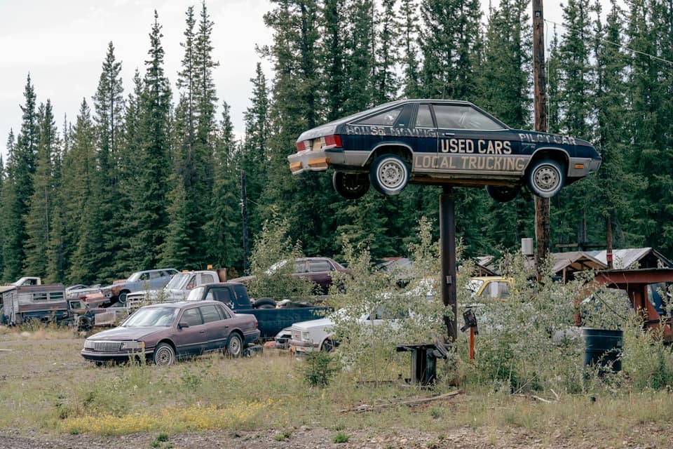 Used car mounted on pole above junkyard